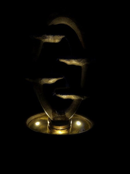Ellipse fountain flowing back and forth scuppers nighttime lighting